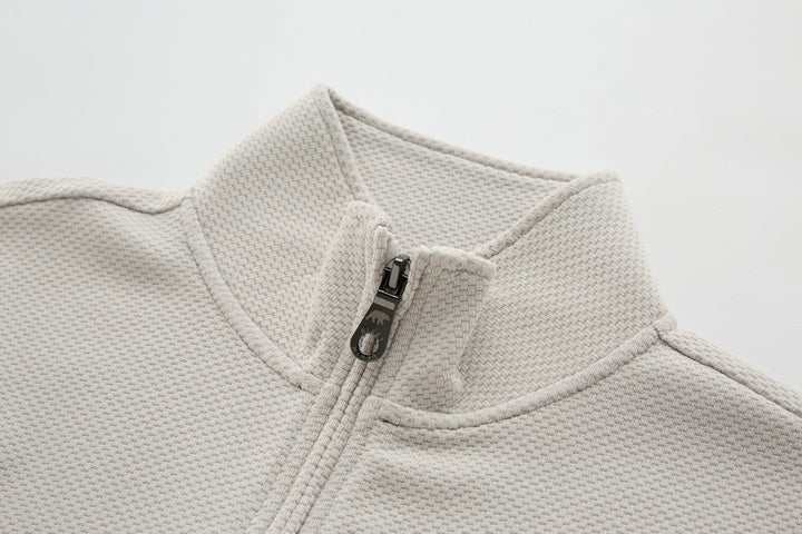 Light beige waffle-knit quarter-zip top with metal zipper at neckline