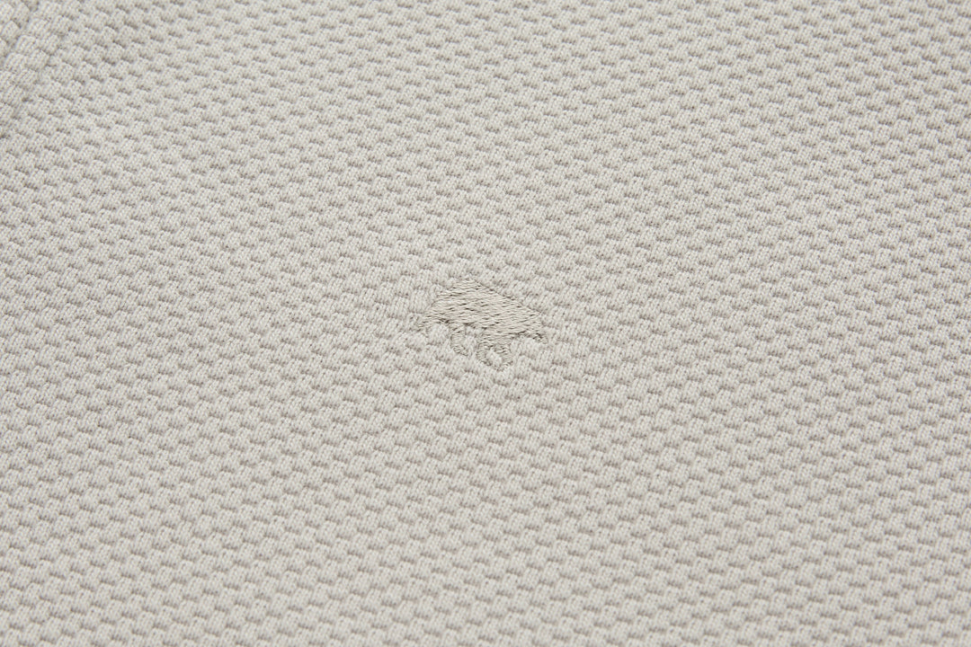 Light beige waffle-knit fabric texture on 1/4-zip top