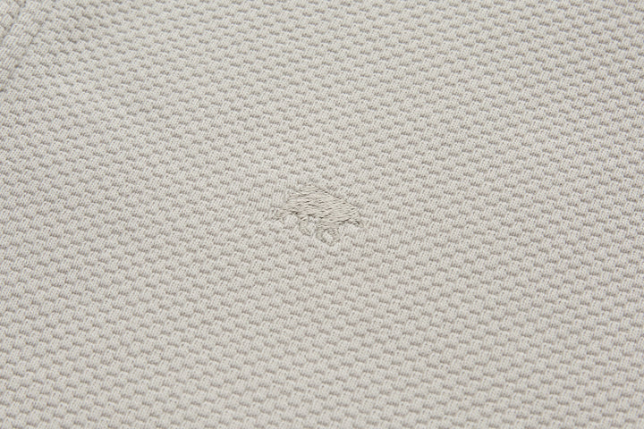 Light beige waffle-knit fabric texture on 1/4-zip top