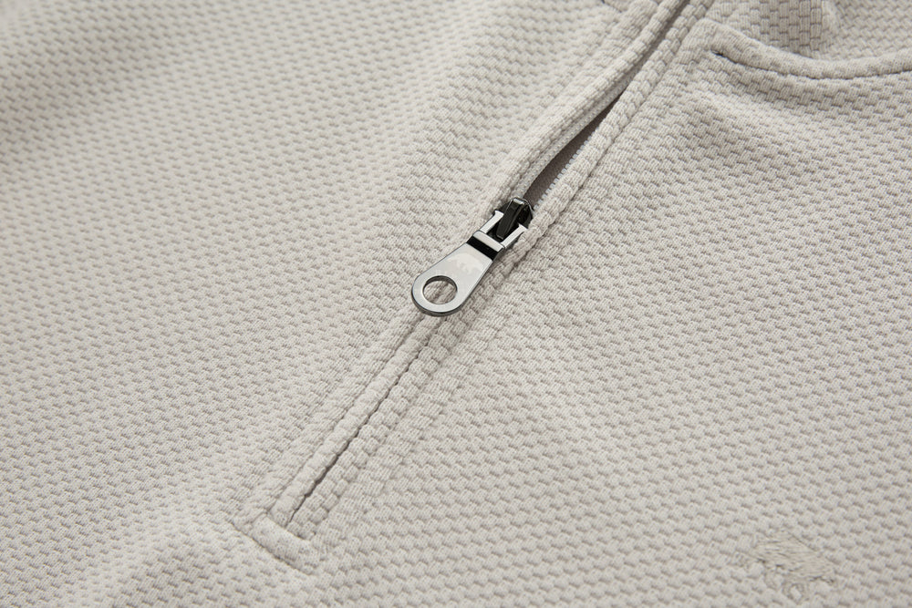 Light beige zipper placket with metal ring pull on 1/4-zip top