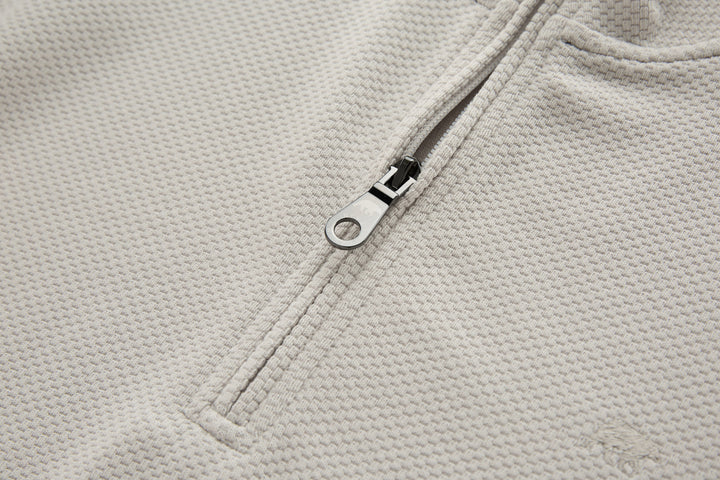 Light beige zipper placket with metal ring pull on 1/4-zip top
