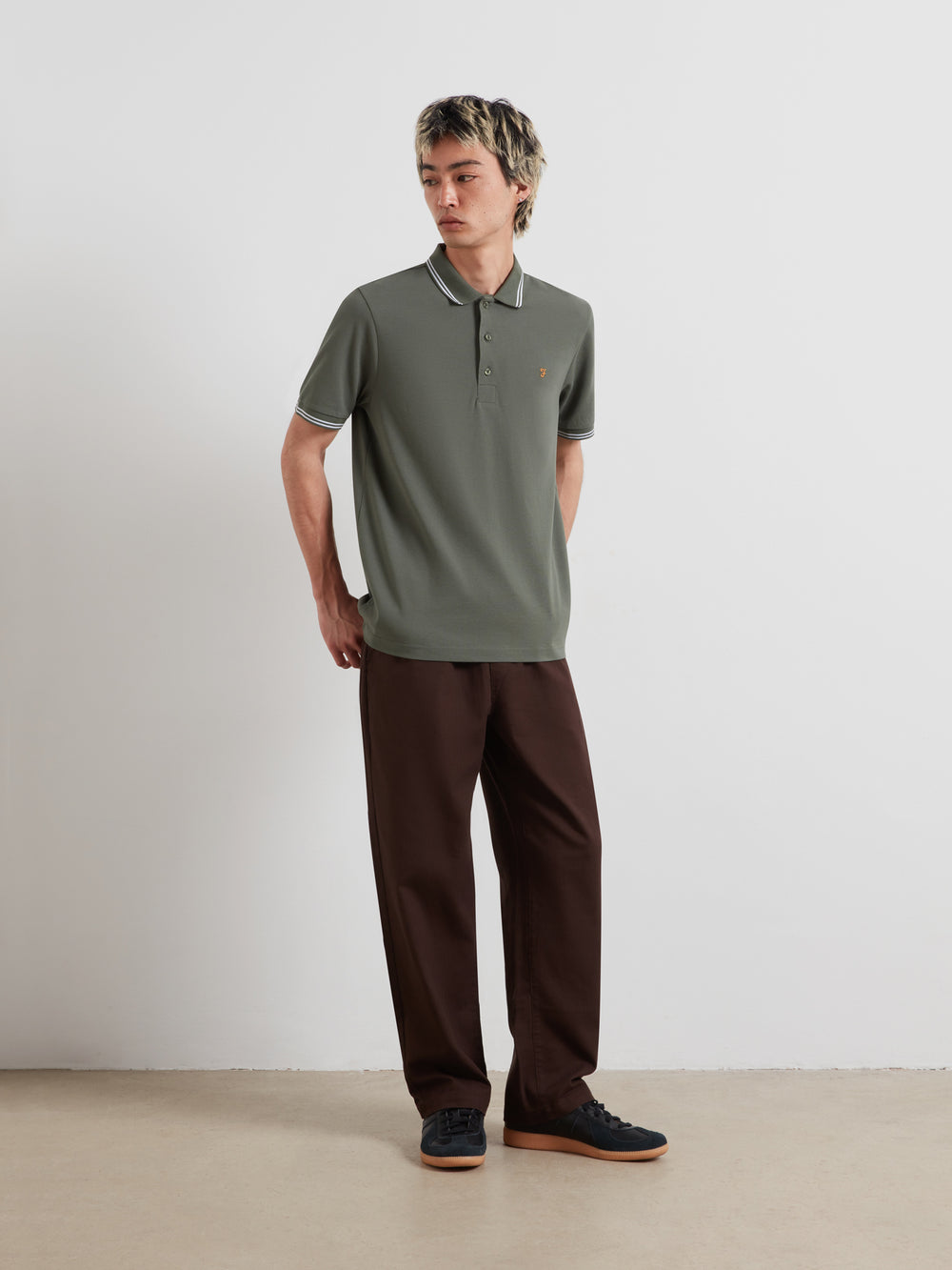 Olive green polo shirt with striped tipping at collar and cuffs; short sleeves, button front