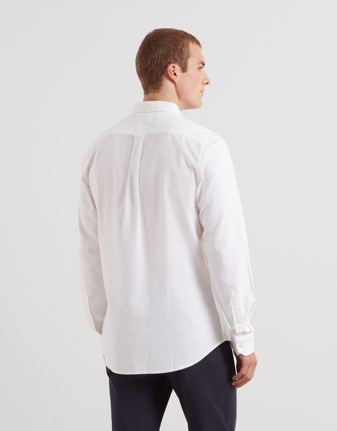 Slim-fit white Oxford button-up shirt, back view with collar and yoke