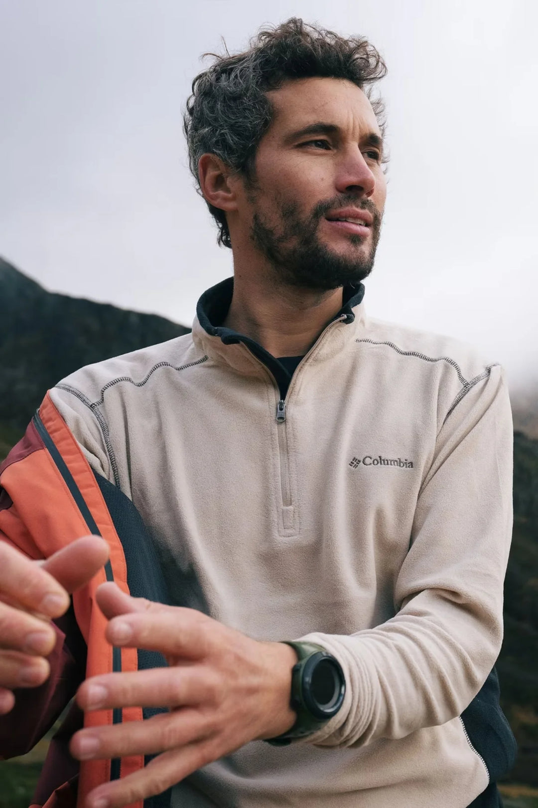 Half-zip fleece top with beige body and dark side panels, chest logo