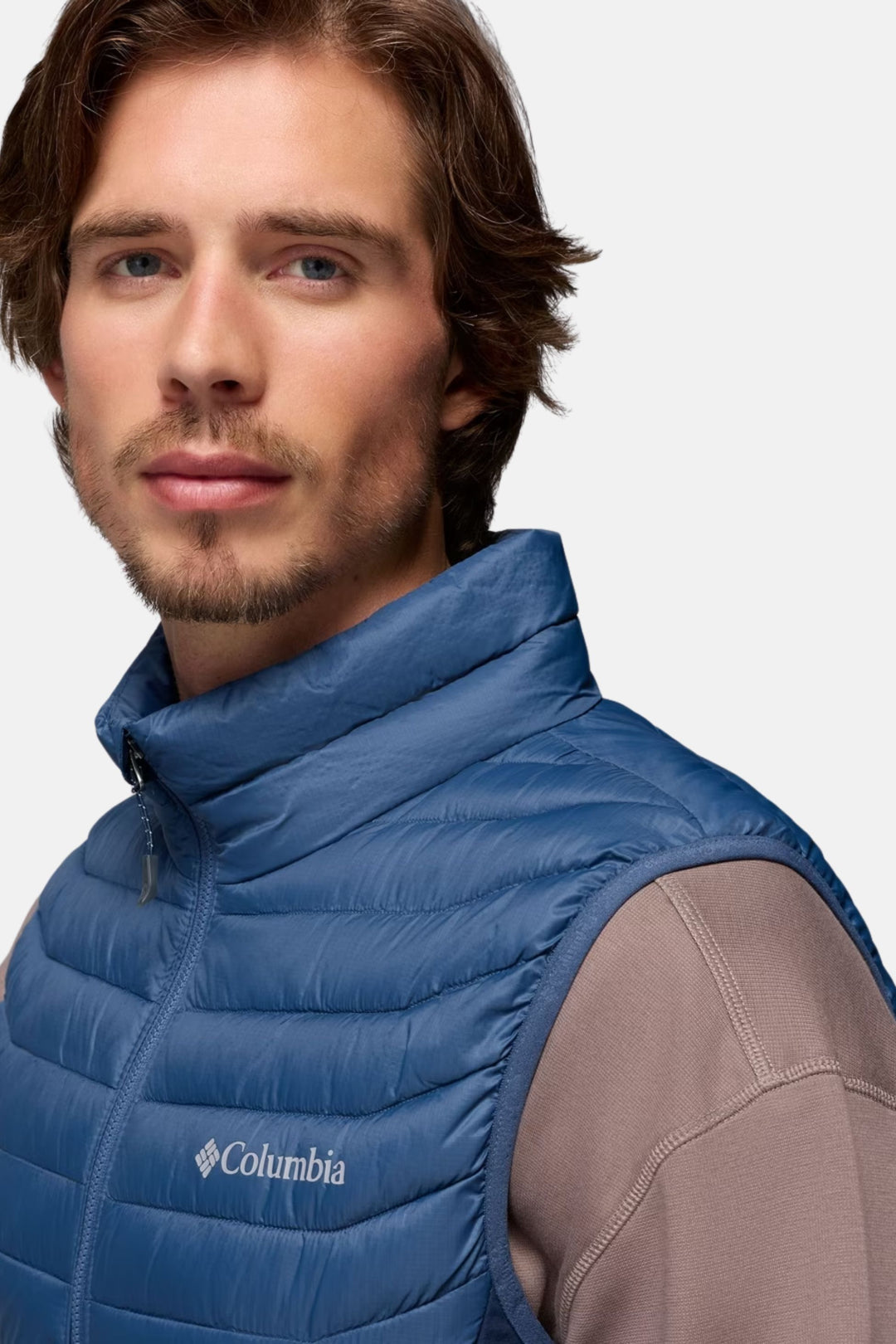 Men's blue puffer vest with high collar and chest logo patch