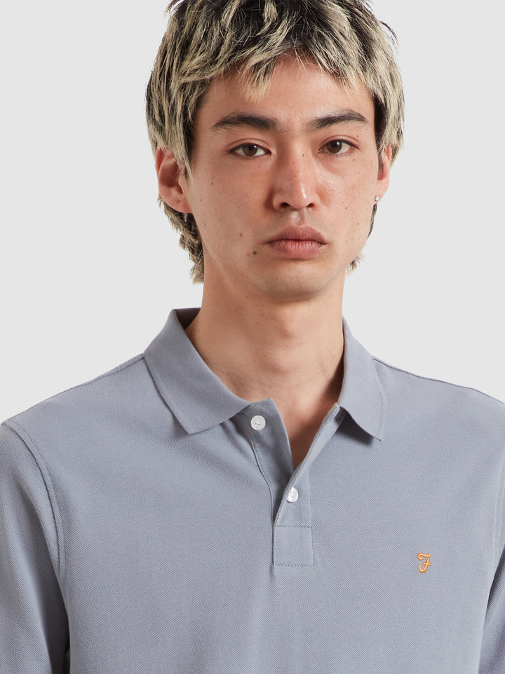 Light blue polo shirt with button placket, short sleeves, and small chest logo
