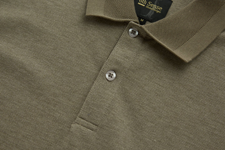 Brindle polo shirt front placket with two visible white buttons and textured fabric.
