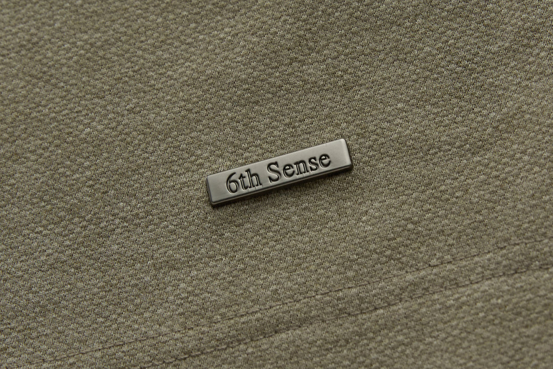 Brindle polo shirt chest logo plate in brushed metal finish.