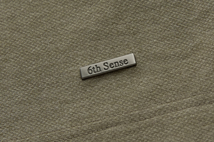 Brindle polo shirt chest logo plate in brushed metal finish.