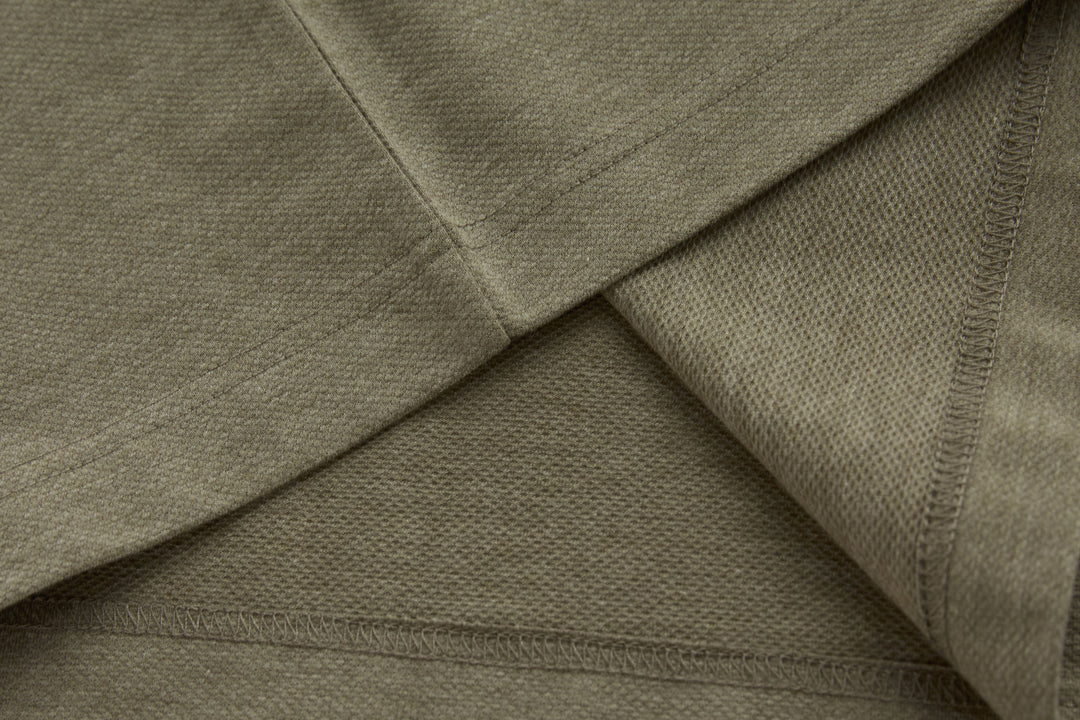Brindle polo shirt side seam and underarm panel detail on a long sleeve.