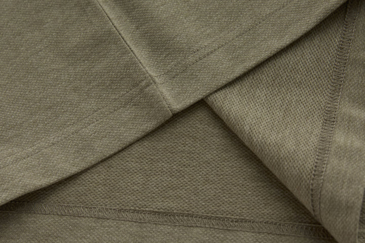 Brindle polo shirt side seam and underarm panel detail on a long sleeve.