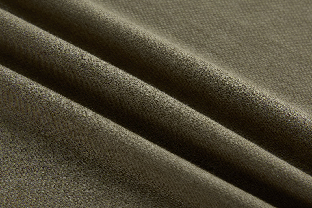 Brindle polo shirt knit fabric close-up with fine dotted texture.