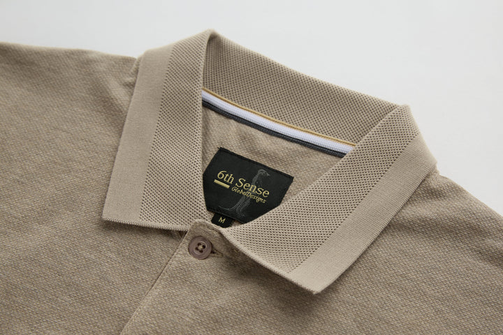 Beige long-sleeve polo shirt collar with button placket and brand label.