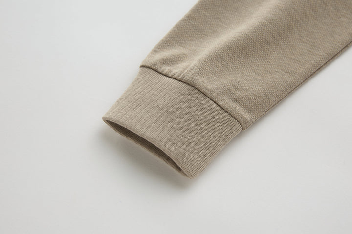 Beige long-sleeve polo shirt sleeve cuff with folded hem.