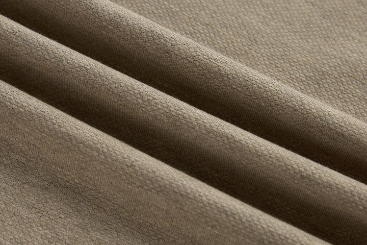 Beige long-sleeve polo shirt fabric close-up with textured knit weave.