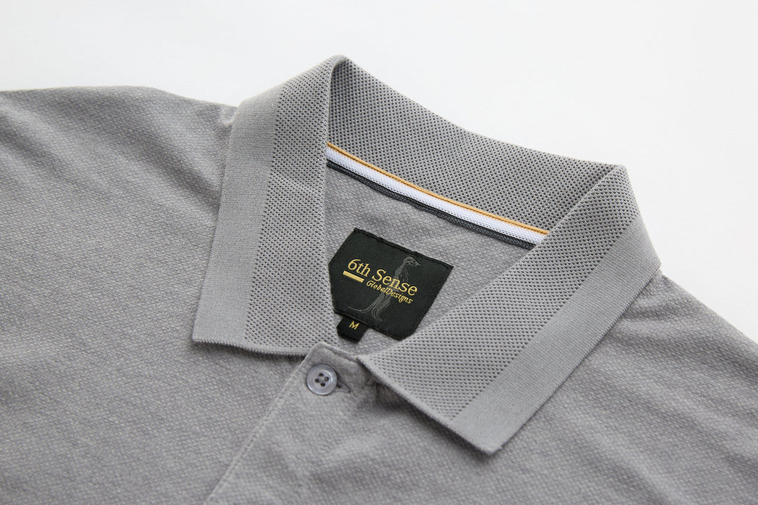 Light gray polo shirt collar with button placket and inner neck label.