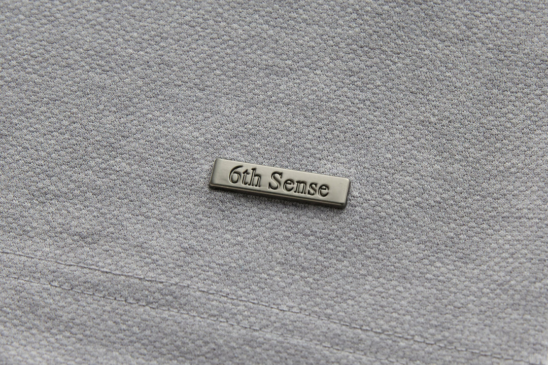 Long-sleeve polo shirt with embroidered brand label, light gray fabric.