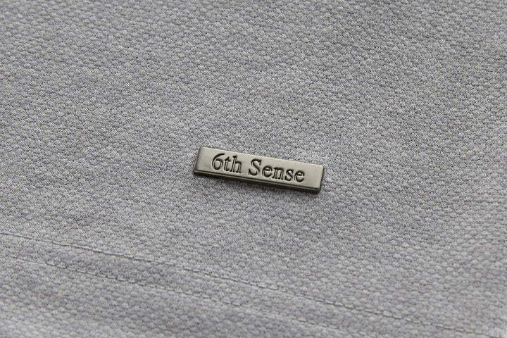 Long-sleeve polo shirt with embroidered brand label, light gray fabric.