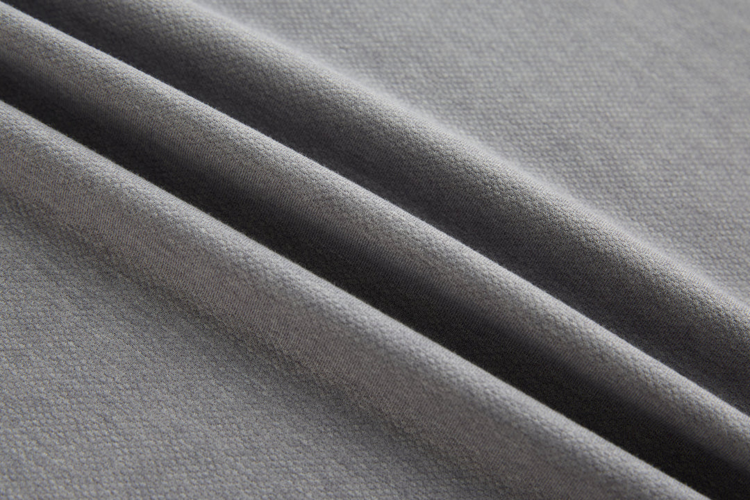 Long-sleeve polo shirt texture close-up, light gray knit.
