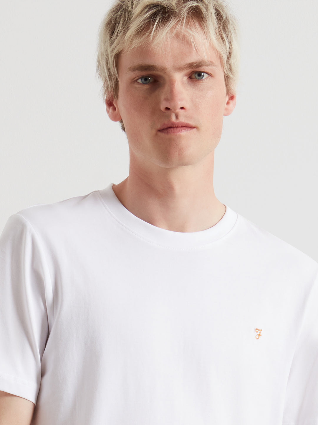 White crew-neck T-shirt with small Farah chest logo detail, close-up