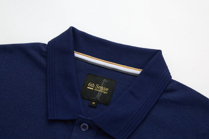 Dress blue polo shirt with ribbed collar and button placket; brand tag at neckline