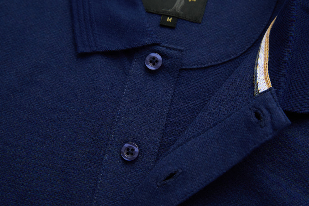 Dress blue polo shirt placket and collar with contrast-striped inner facing detail