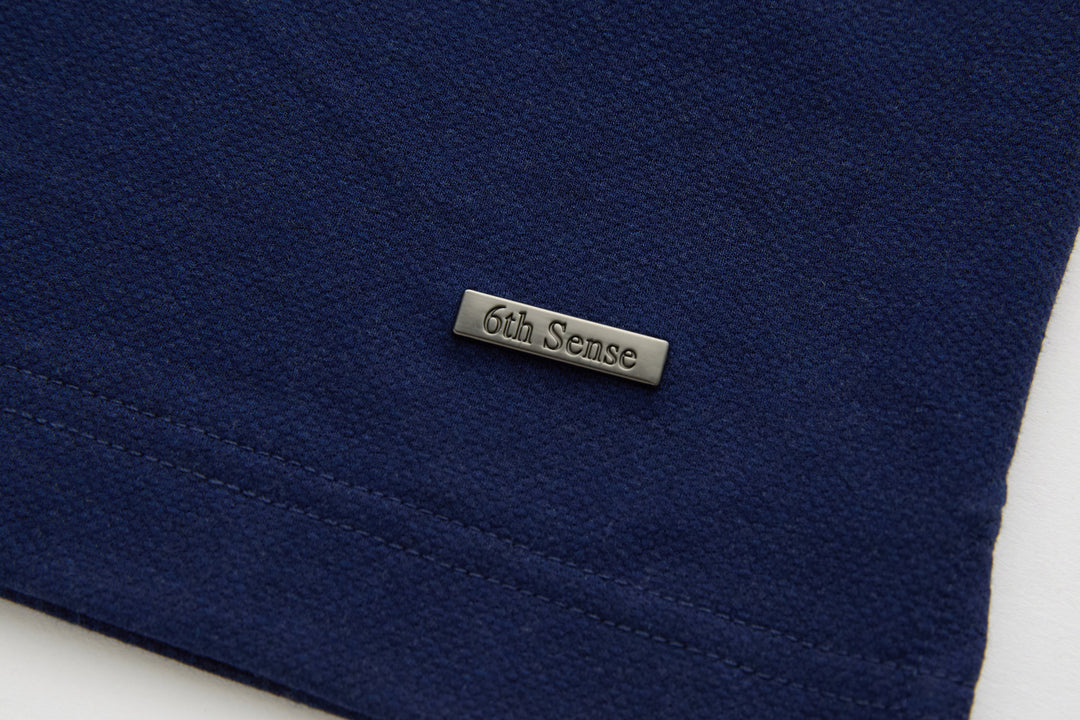 Dress blue polo shirt with small 6th Sense neck label on the front hem area