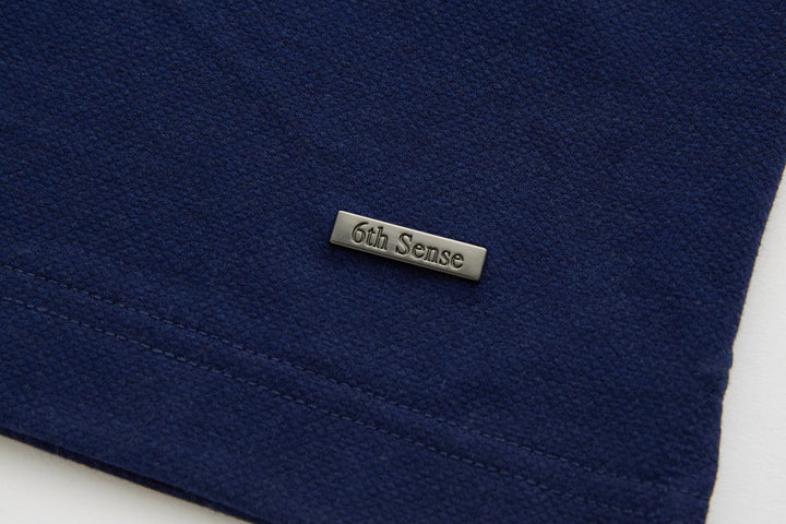 Dress blue polo shirt with small 6th Sense neck label on the front hem area