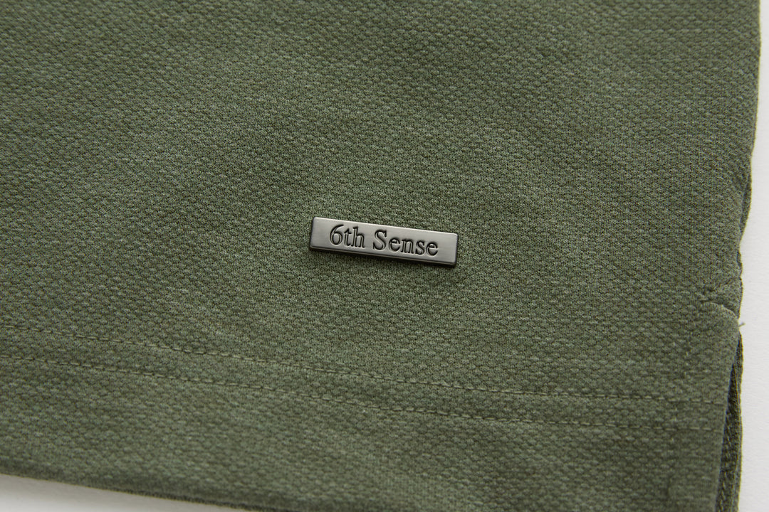 Olive polo shirt 6th Sense hem label with stitched edge close-up