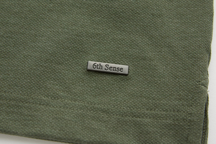 Olive polo shirt 6th Sense hem label with stitched edge close-up