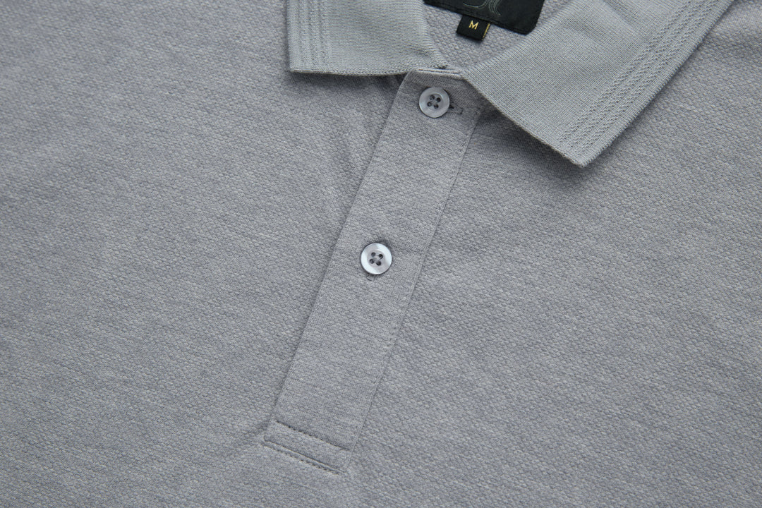 Light gray polo shirt placket with white button closures