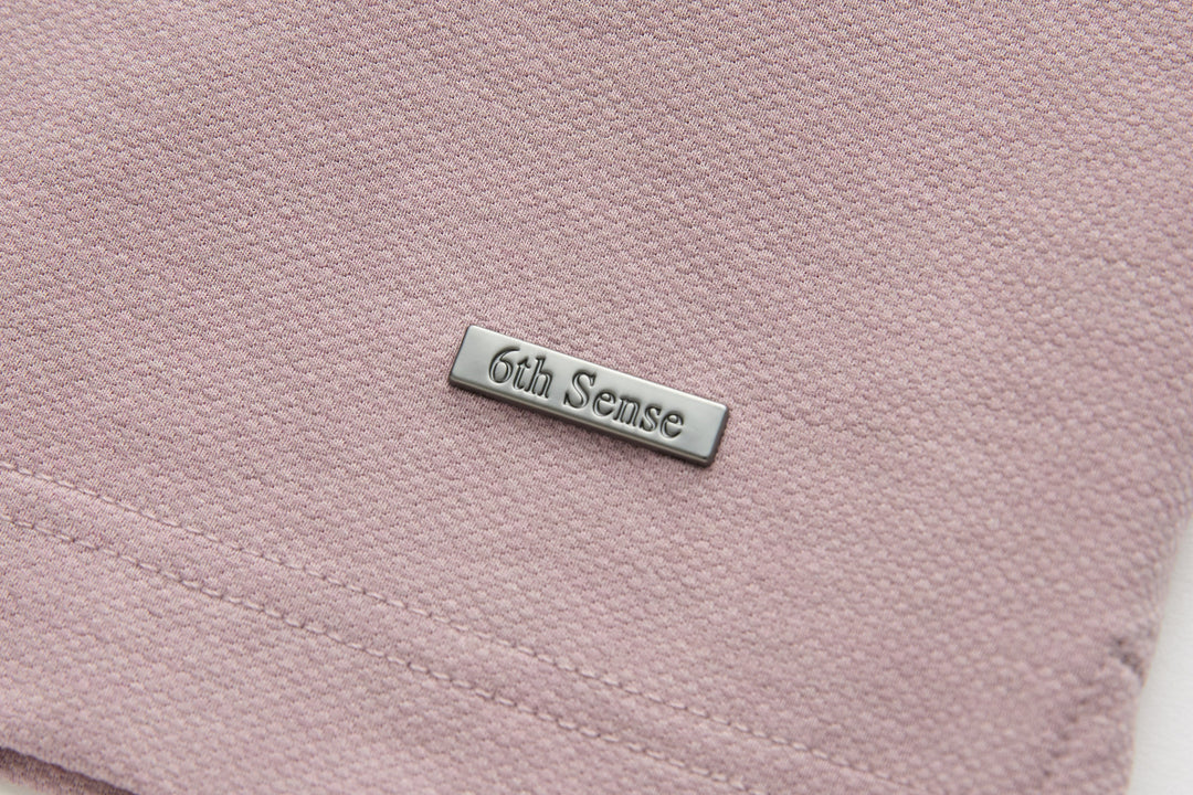 Woodrose polo shirt chest pocket and 6th Sense metal logo patch