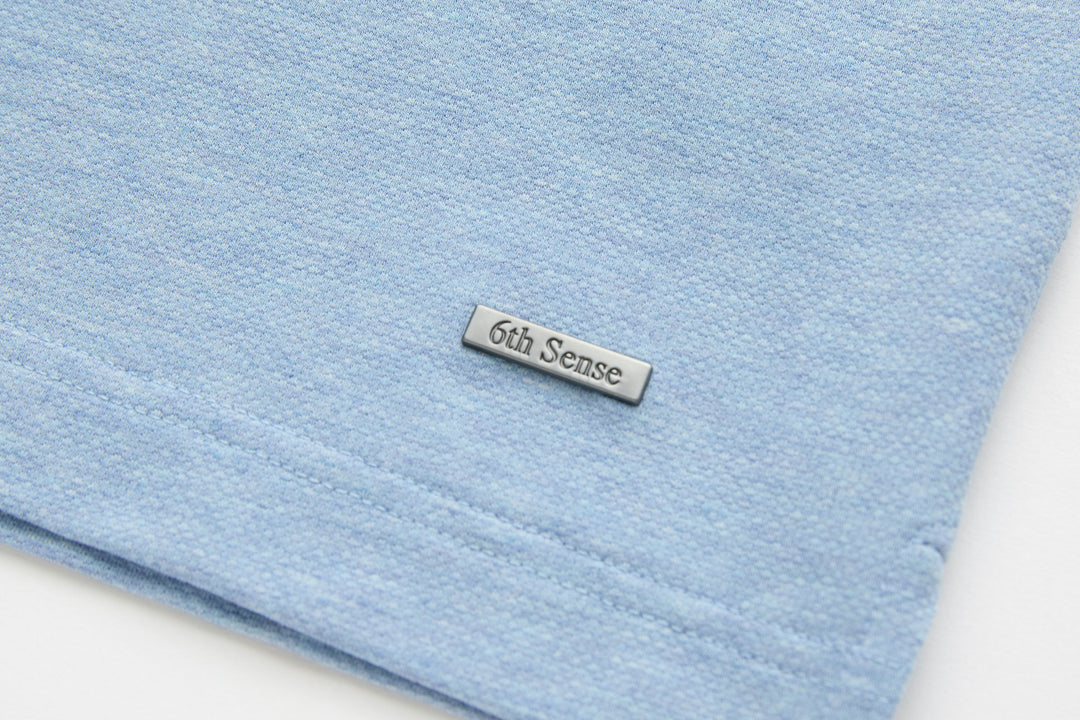 Sky blue polo shirt hem with embroidered 6th Sense logo patch