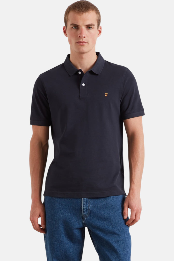 Men's navy polo shirt with short sleeves, button placket, and small chest logo