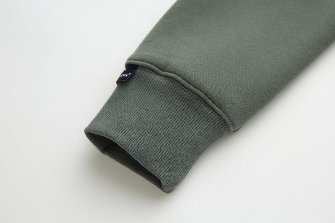 Olive 1/4-zip top sleeve cuff with ribbed knit hem