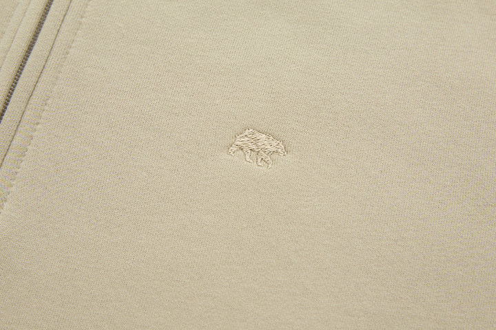Beige 1/4-zip top with small embroidered logo on chest