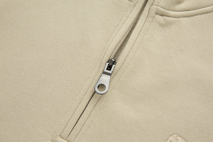Beige 1/4-zip top with metal zipper and stitched placket