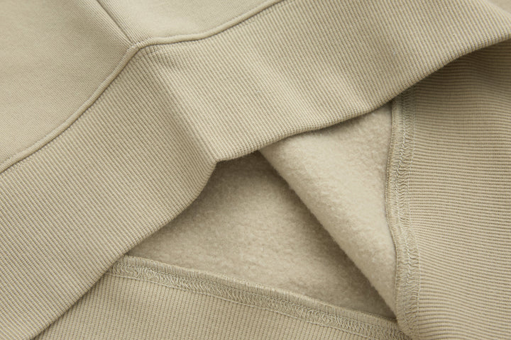 Beige 1/4-zip top showing ribbed waistband and inner fabric lining
