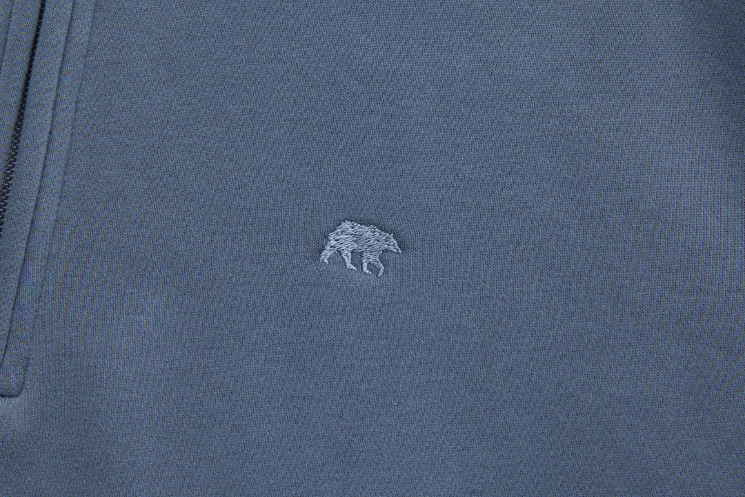 Blue 1/4-zip top with small chest logo embroidery