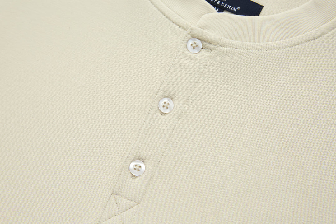 Bone denim top front with two white button fasteners, close-up