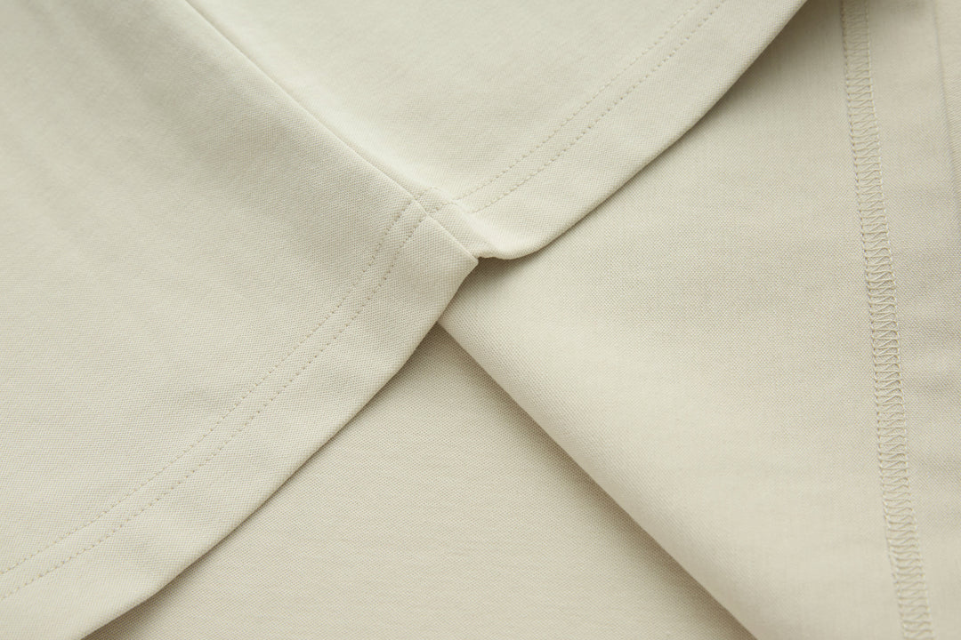 Bone denim top hem and side seam detail, folded close-up