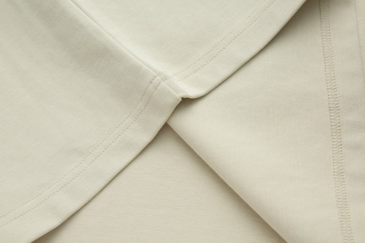 Bone denim top hem and side seam detail, folded close-up