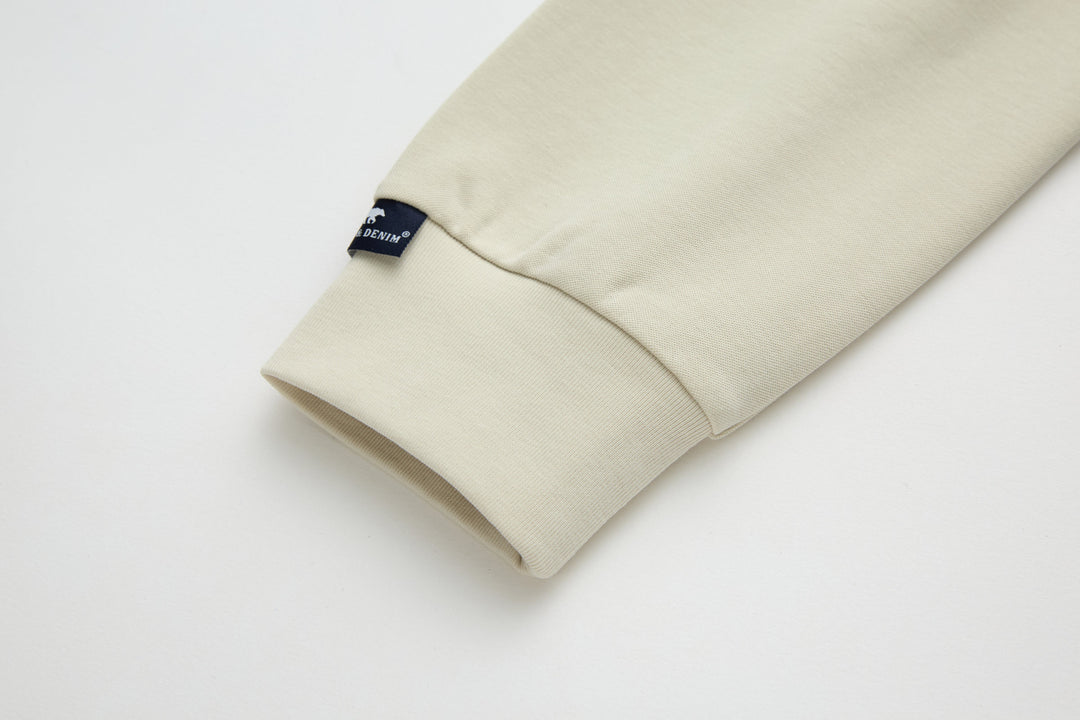 Bone denim top sleeve and cuff, small brand label visible