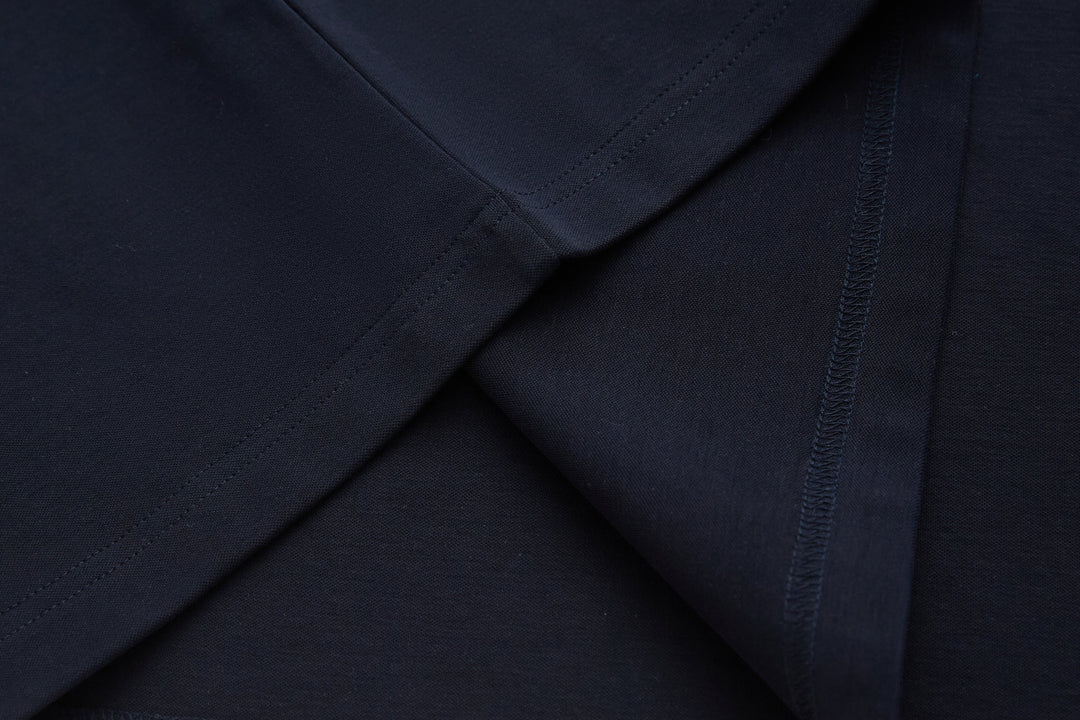 Navy long-sleeve top with stitched cuff and sleeve seam detail