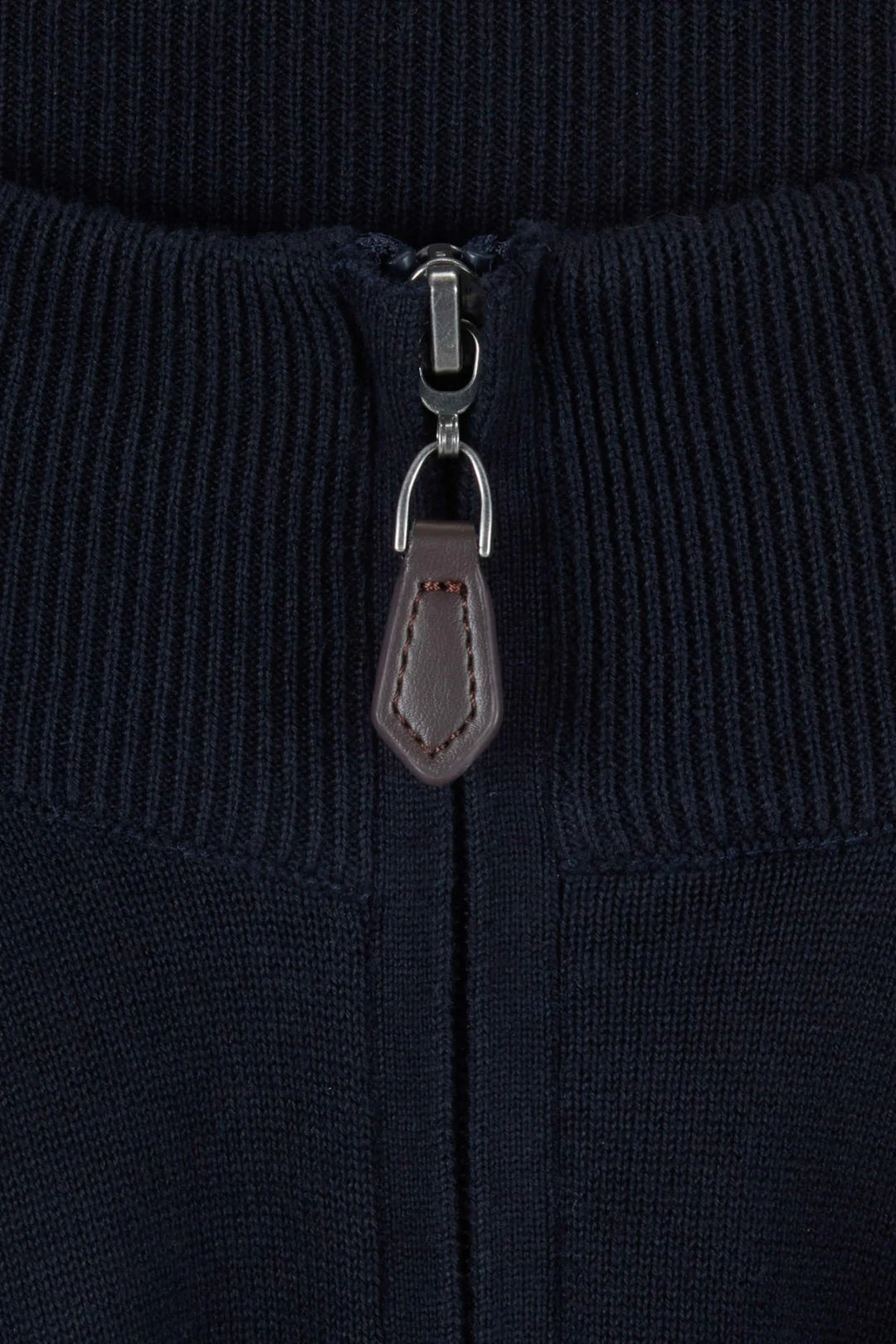 Close-up of navy 1/4-zip knit jumper with metal zipper pull and leather tab