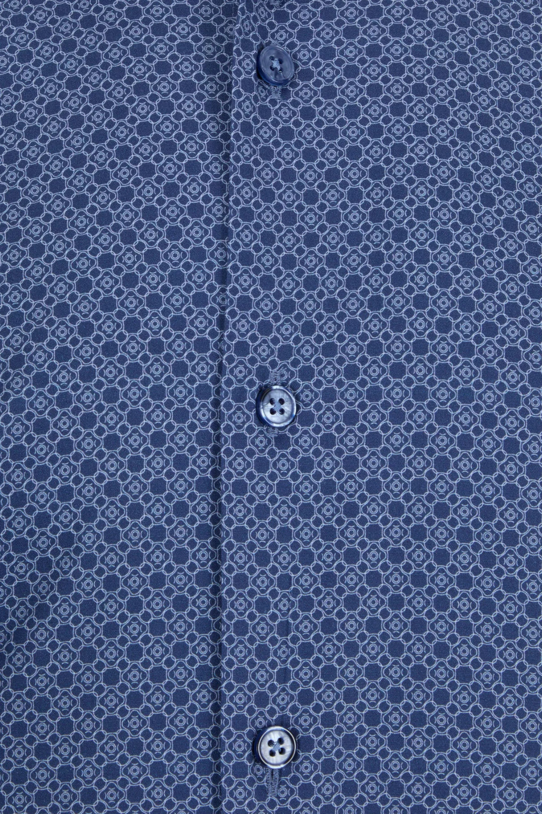 Dress shirt close-up: blue geometric print with black buttons.
