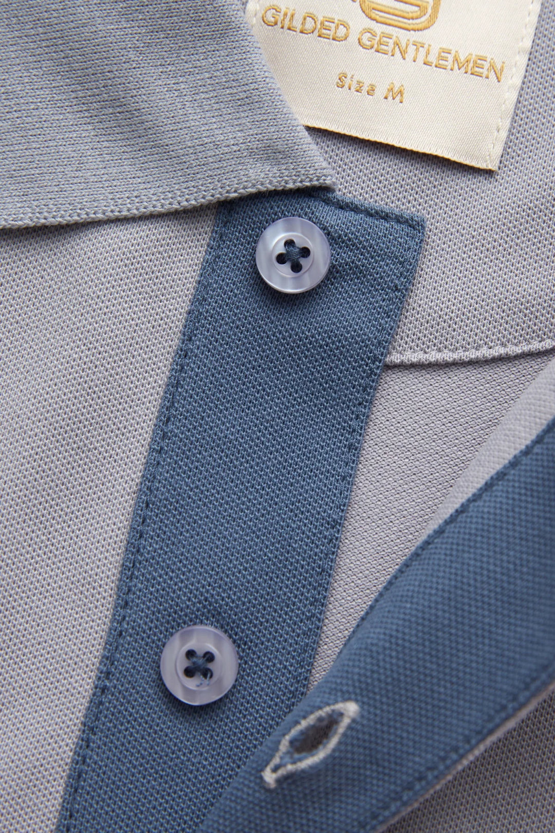 Grey polo shirt with blue inner placket and two-button collar