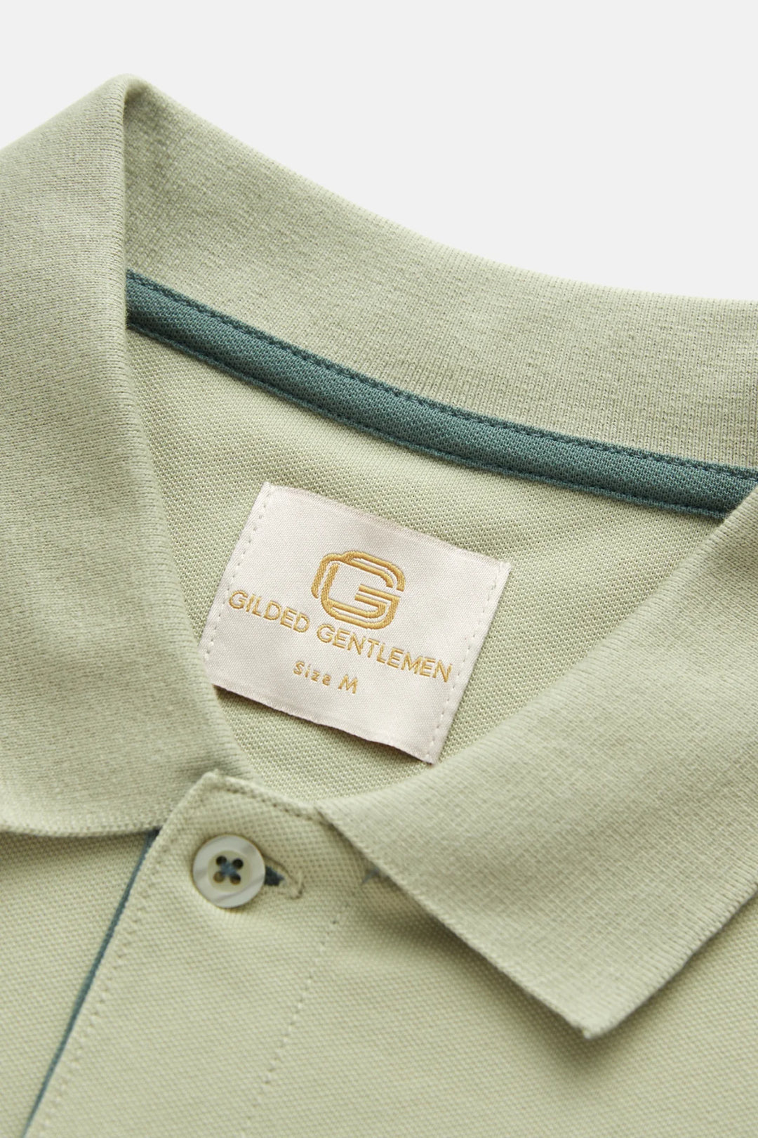 Light green polo shirt neck label with buttoned collar and blue trim