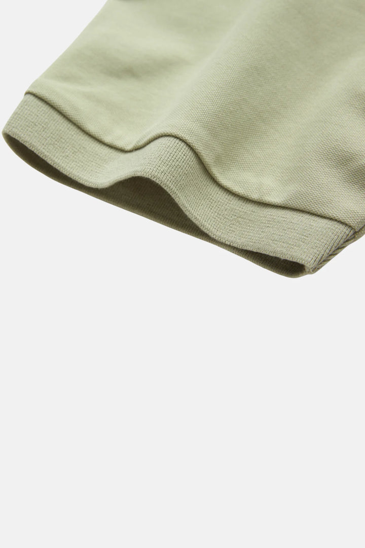 Light green polo shirt sleeve with ribbed cuff and stitched hem
