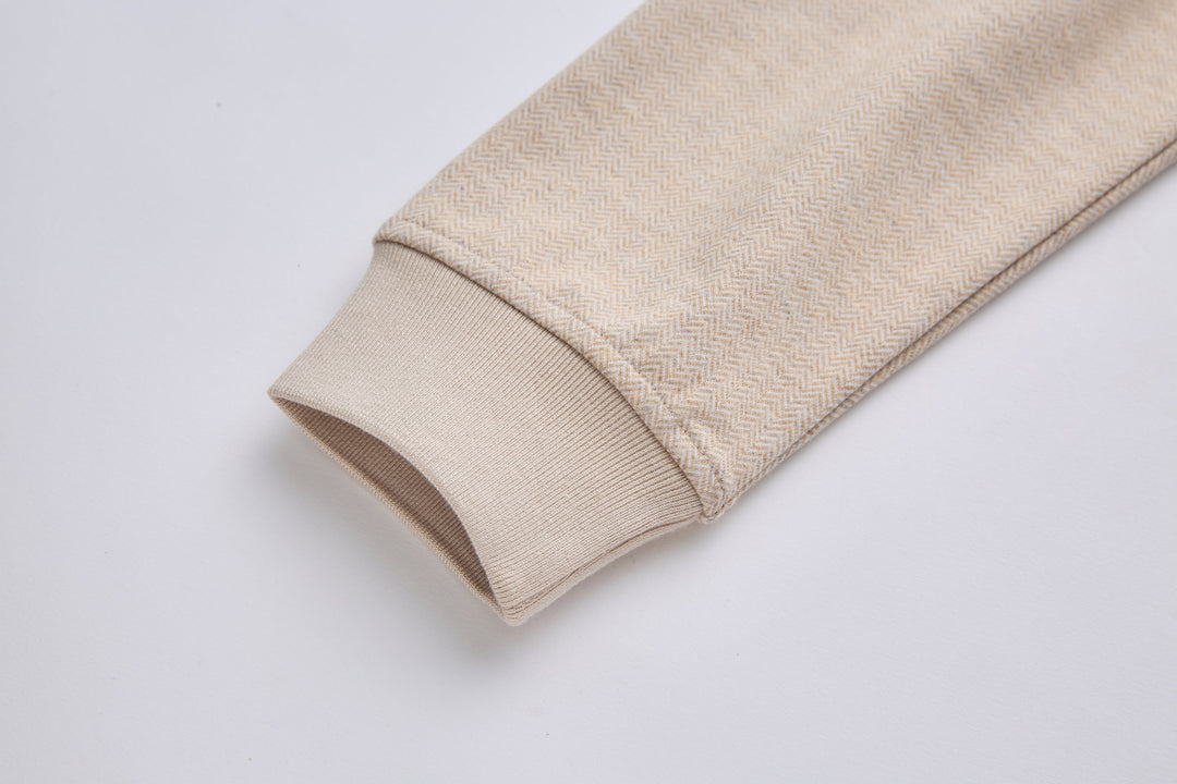 Sleeve cuff with ribbed hem on mushroom-beige herringbone 1/4-zip top